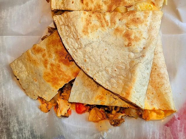 Illustrative photo of a chicken quesadilla cut into wedges